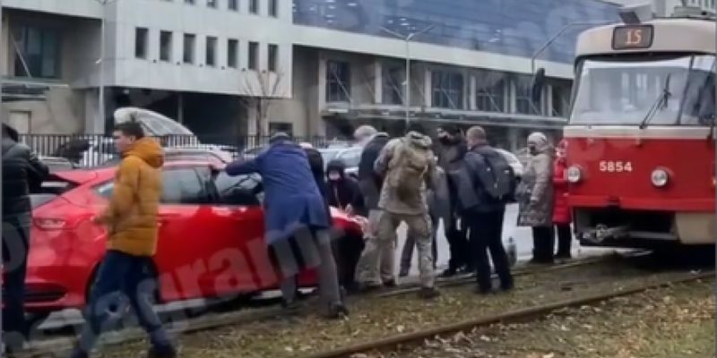Фитнес по дороге на работу: пассажирам киевского трамвая пришлось сталкивать с пути авто