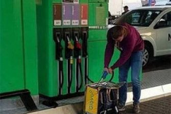 Курйоз: у Києві помітили кур’єра Glovo, який “заправляв” бензин у фірмовий рюкзак